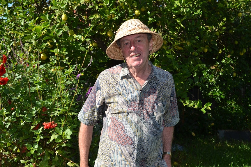 A man standing in front of plants in the garden