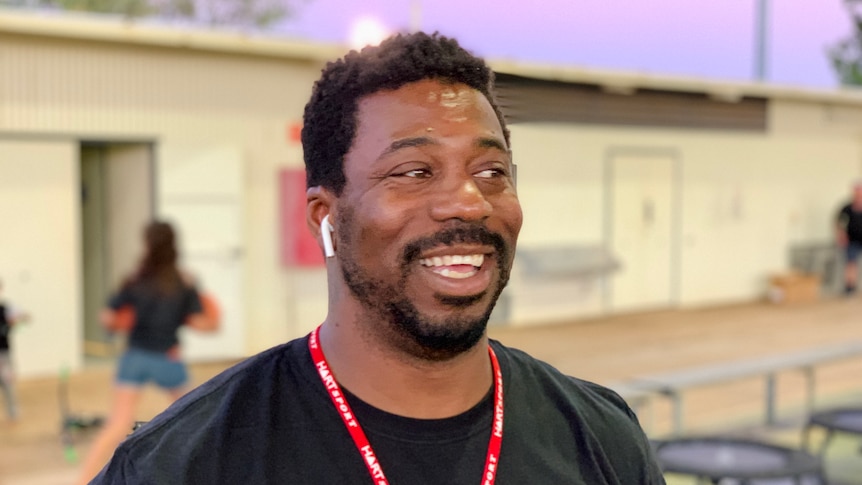 A man with black hair smiles 