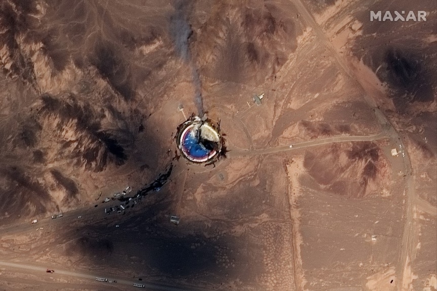 A satellite image of a circular launch site that appears to be smoking