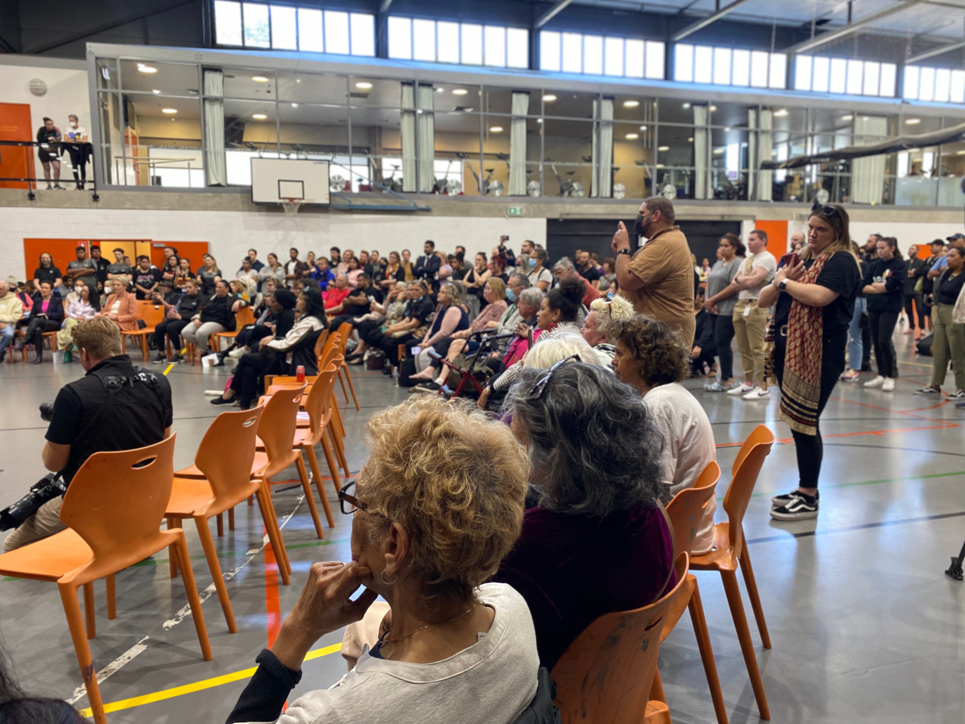 a group of people sitting on chairs at a community meeting