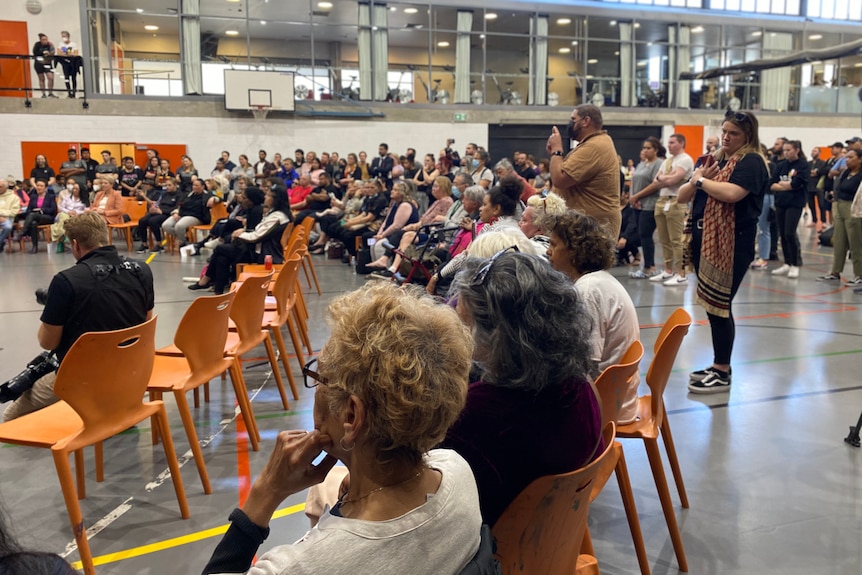 a group of people sitting on chairs at a community meeting