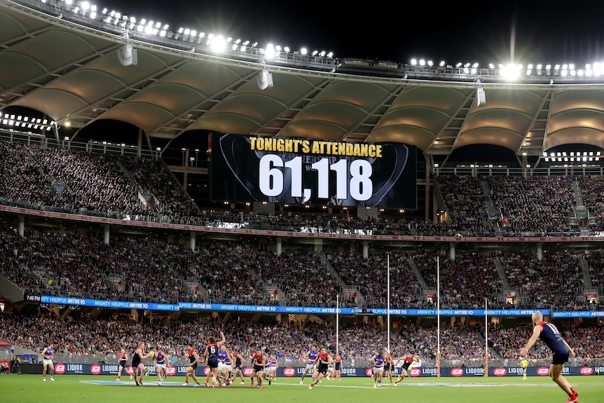 A sign in a packed stadium shows the attendance number