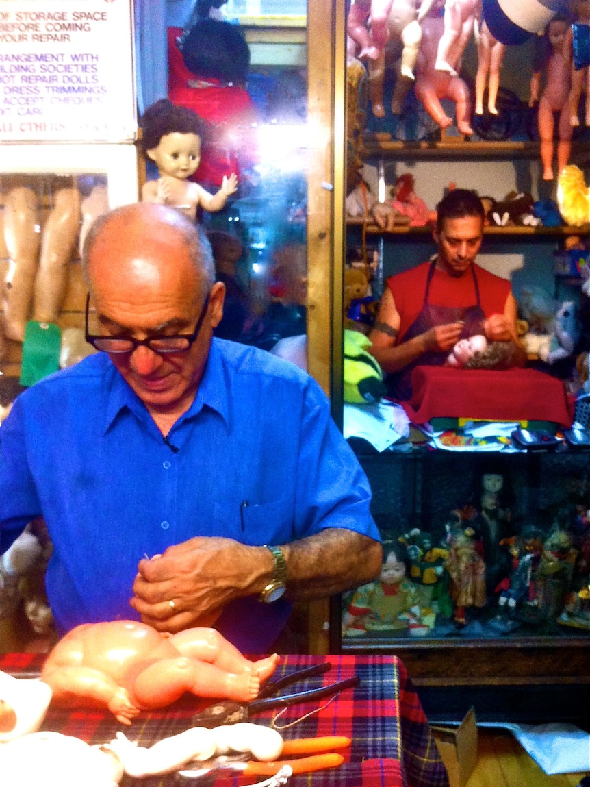 Brisbane doll hospital owner George Georgiou (front) and his trainee, Laki Augustakis, in December 2012