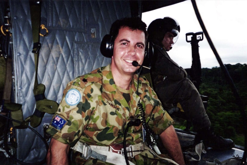 Jeremy Hanson in Army gear in the back of a helicopter.