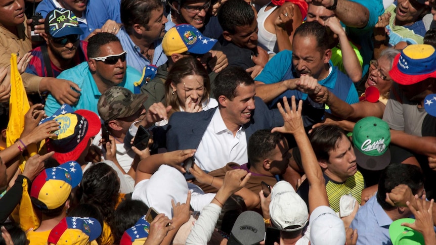 Venezuelan opposition leader Juan Guaido surrounded by a crowd of supporters.