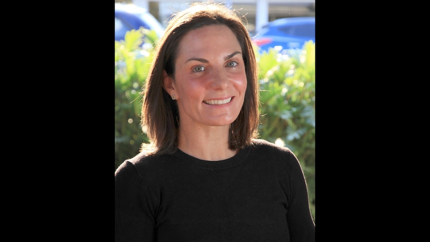 head and shoulders shot of smiling woman in black top