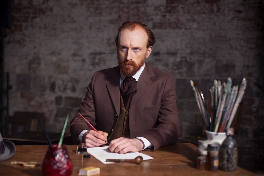 Colour still of Jamie de Courcey sitting at desk as Vincent Van Gogh in 2015 documentary Vincent Van Gogh: A New Way of Seeing.