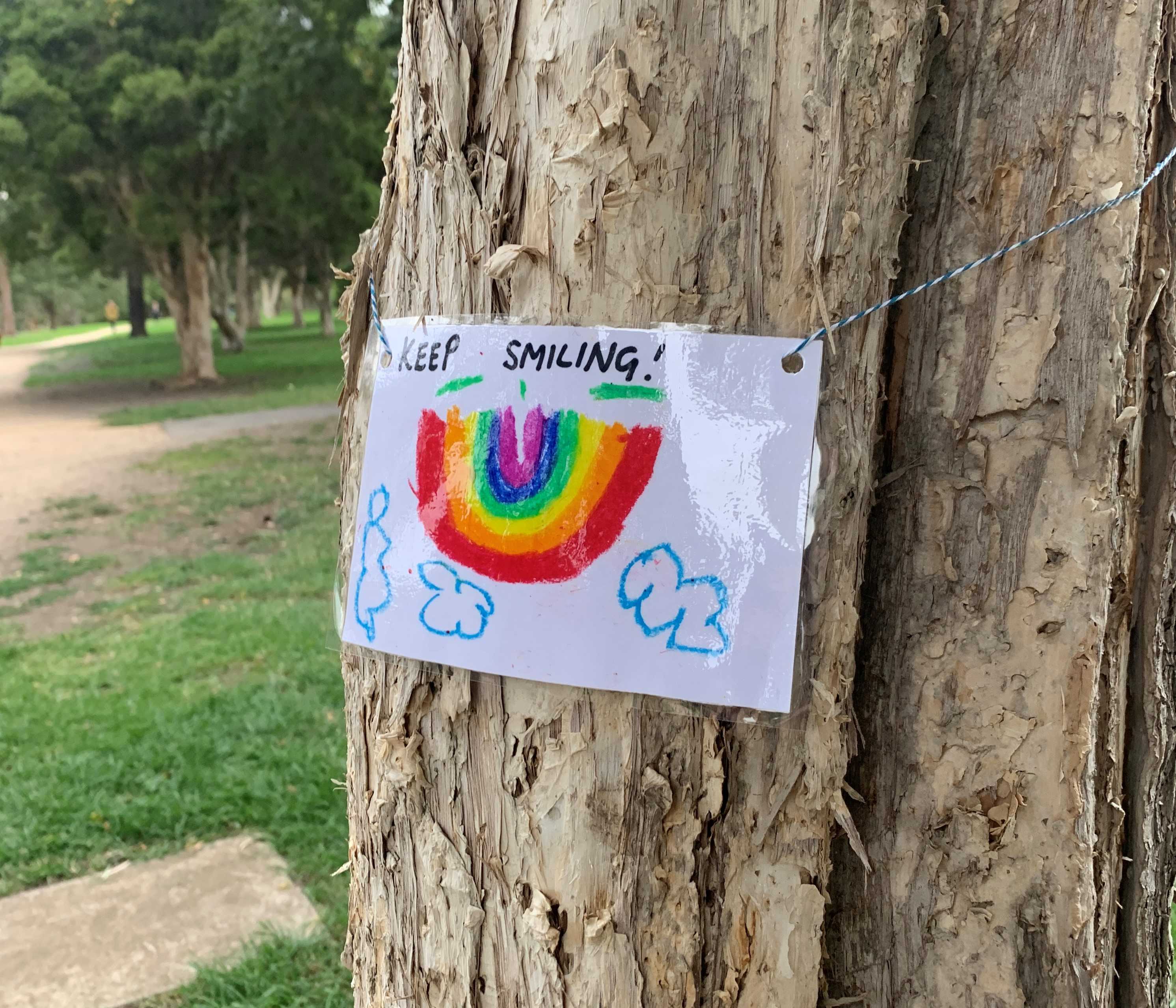 A laminated picture of a rainbow, with the words 'keep smiling' printed above it.