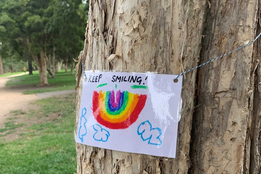 A laminated picture of a rainbow, with the words 'keep smiling' printed above it.