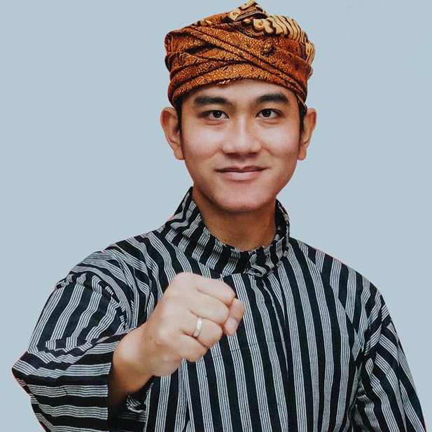 A headshot of an Indonesian man with a headwrap 