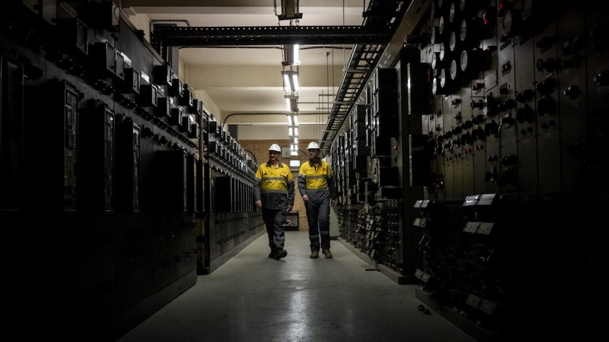 Two men walk through an underground tunnel in Melbourne.