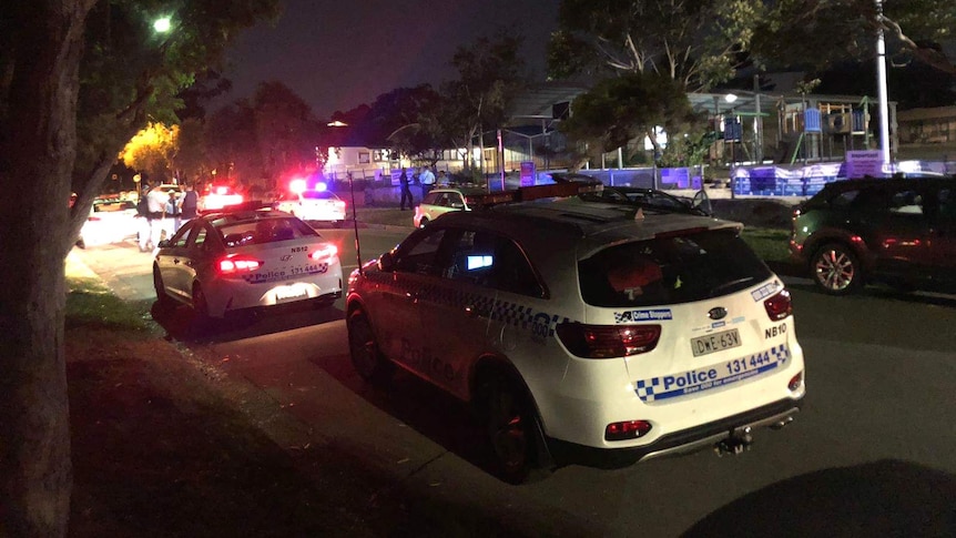 Police cars and police in a street.