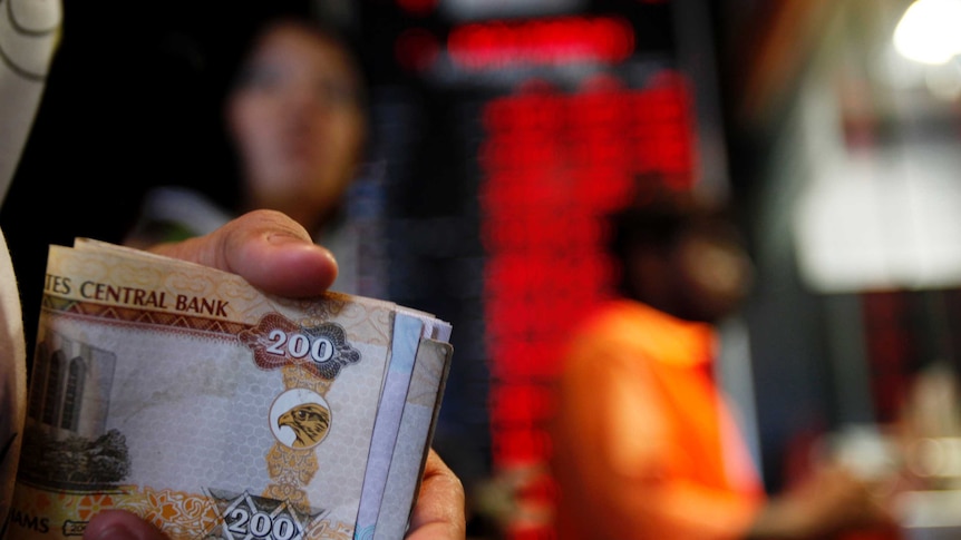 A customer exchanges money at a currency exchange centre in Dubai.