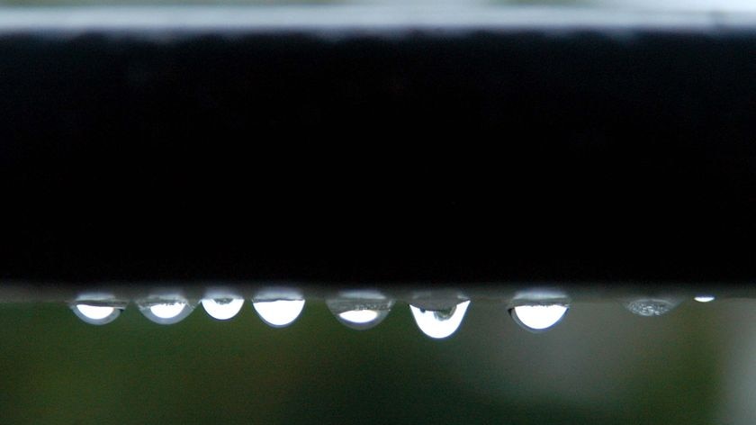 Water drops sit on the underside of a hand rail
