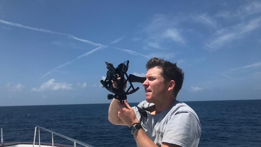 Man with a sextant out at sea.