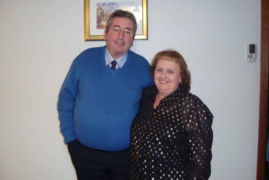 A man wearing a blue jumper and a woman wearing a black spotty top