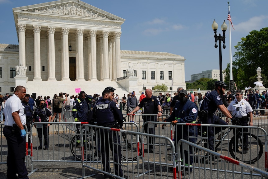 Police officers direct the setup of barricades outside the US Supreme Court