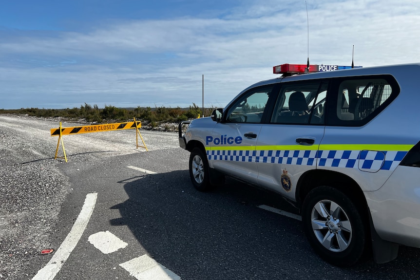 A police car at a closed road.