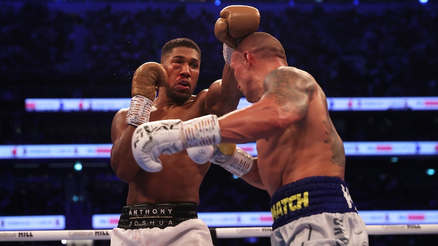 Anthony Joshua, with a damaged eye, punches over the head of Olaksandr Usyk