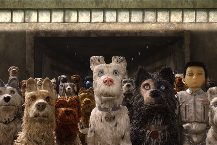 Colour still image of the dog puppets and boy character from 2019 stop-motion animation Isle of Dogs.