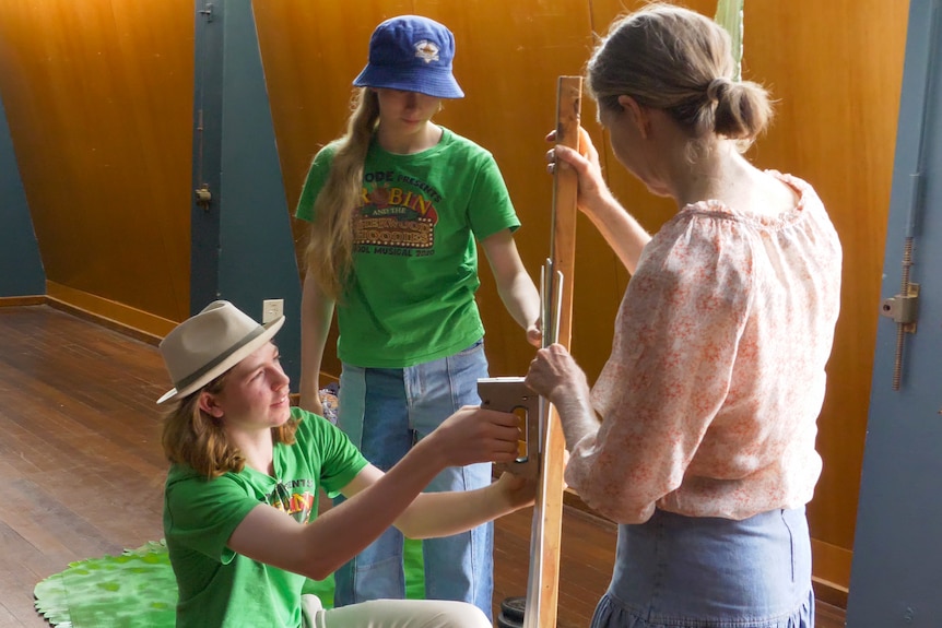 Dom Faggotter and his family using a staple gun to assemble prop trees, Longreach, November 2023.