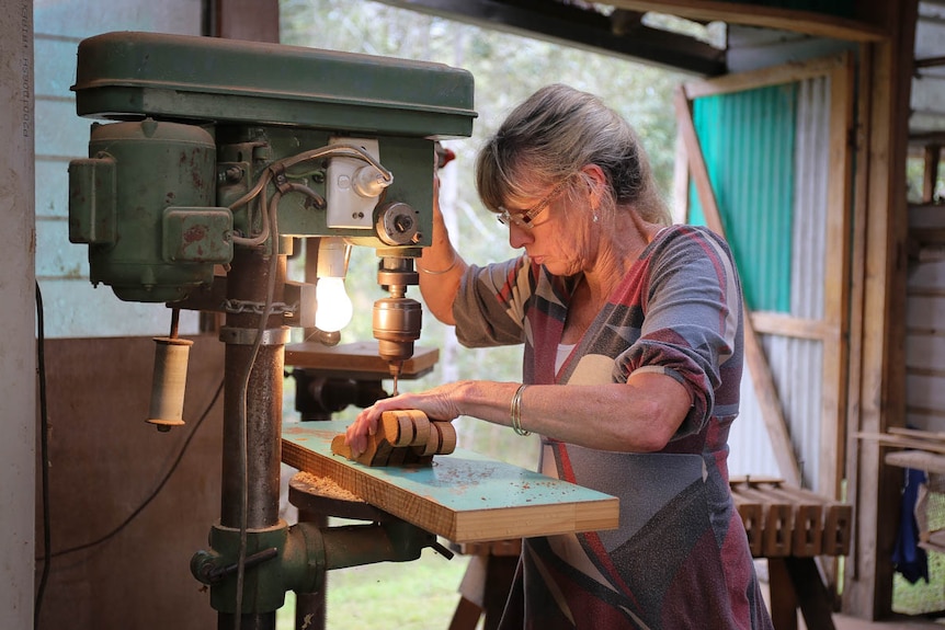 Woman drilling piece of wood