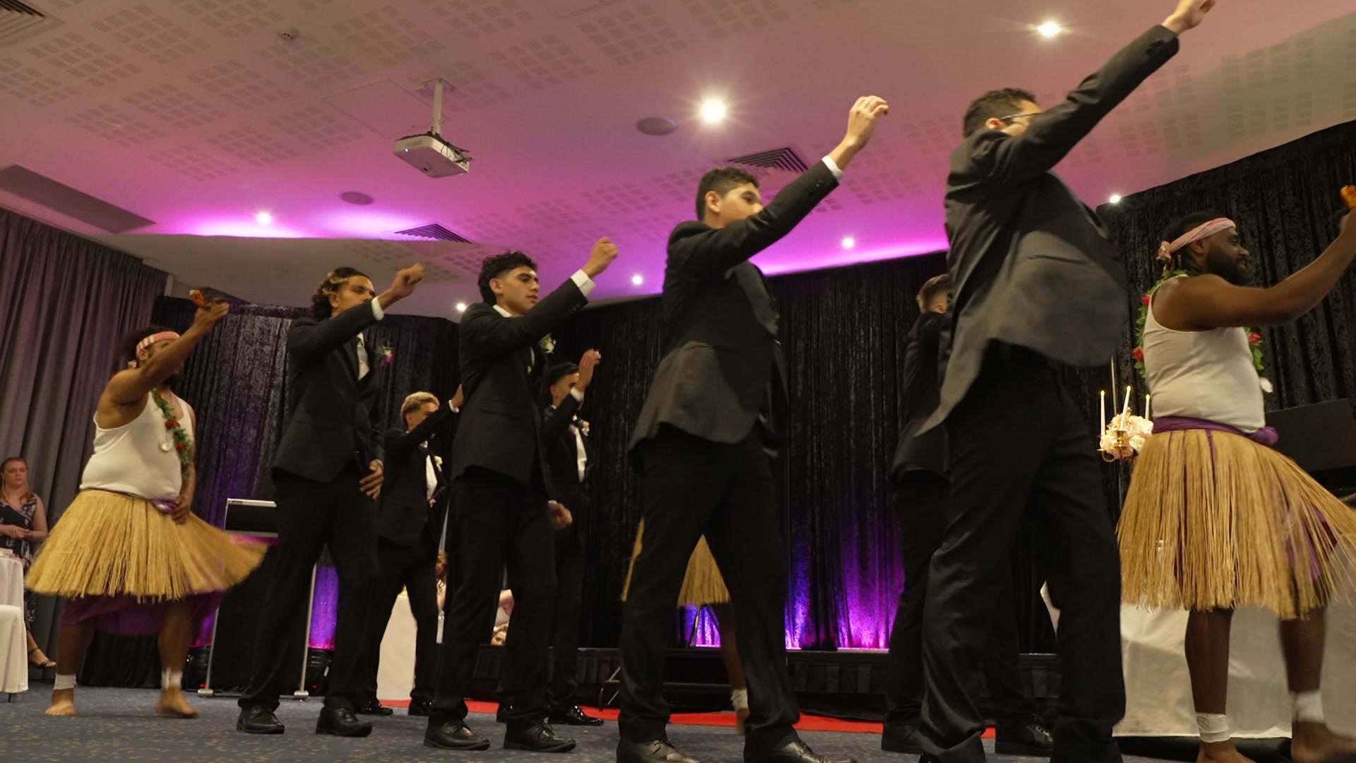 a line of four young boys dressed in suits dancing