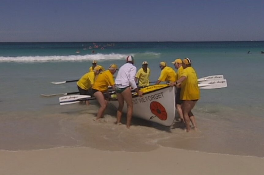WA surf life savers push a surf boat together