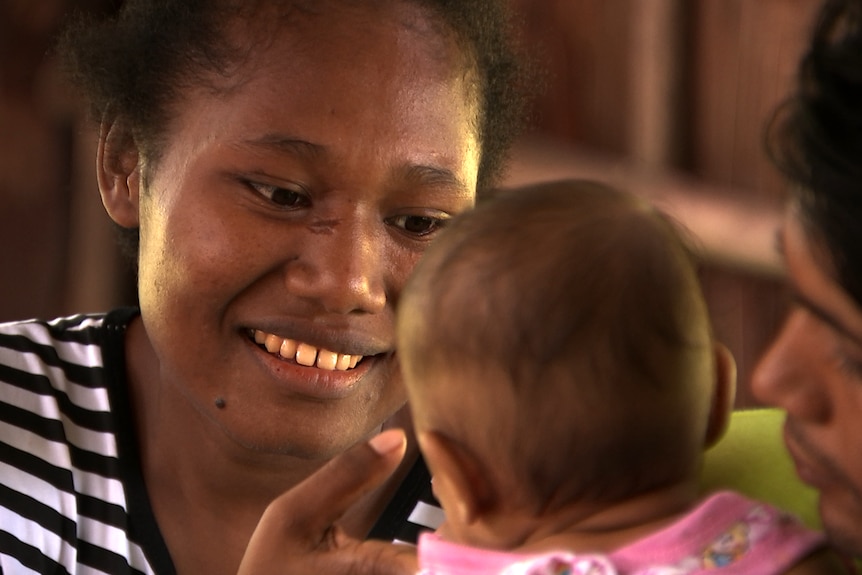 Alice Michael holds baby Mohammad and smiles.