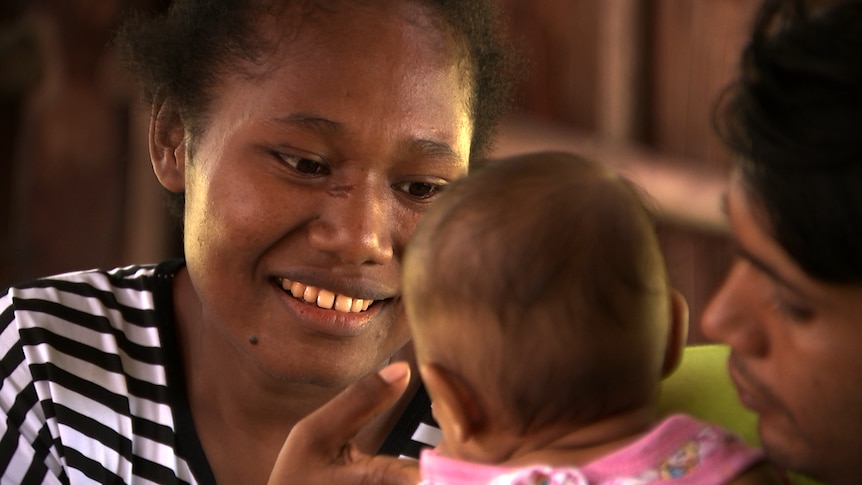 Alice Michael holds baby Mohammad and smiles.