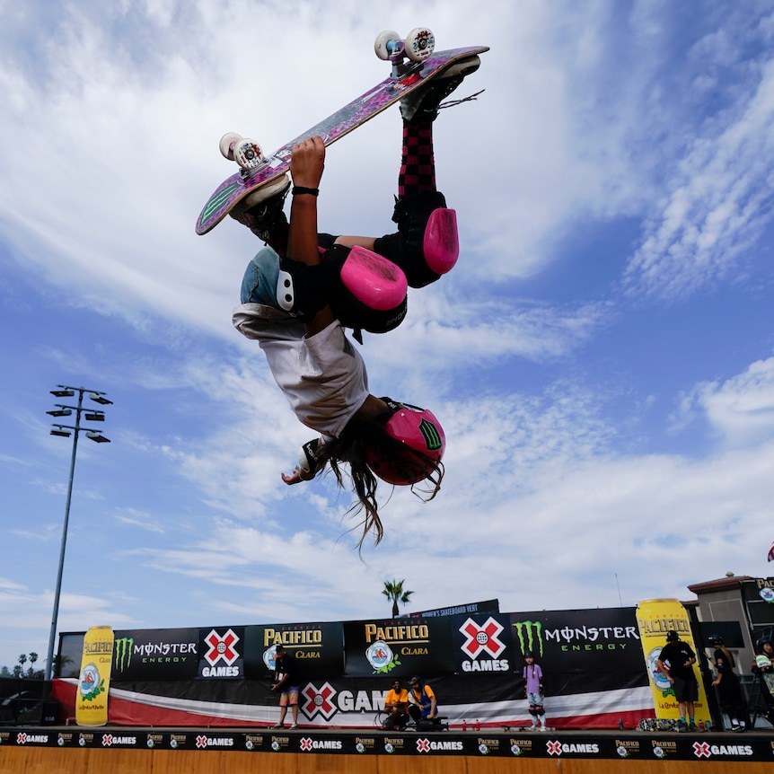 Arisa Trew upside down on a skateboard. 