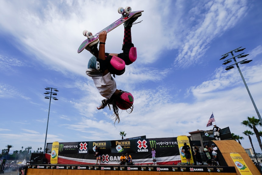 Arisa Trew upside down on a skateboard. 