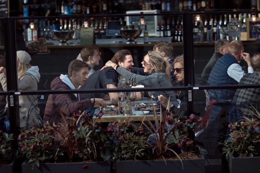 A couple hugs and laughs as they have lunch in a restaurant in Stockholm
