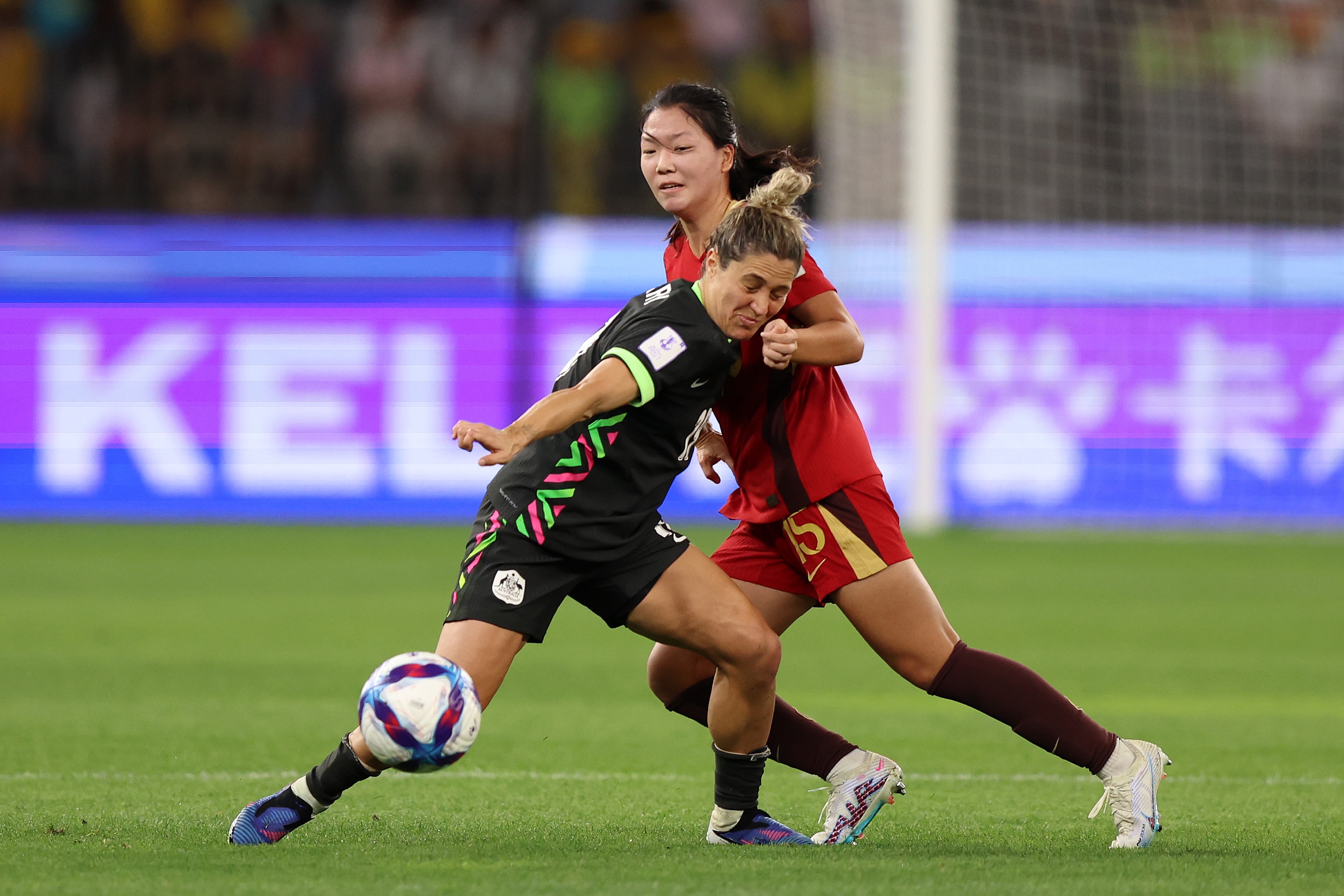 Dois jogadores de futebol, um de azul e outro de vermelho, disputam a bola