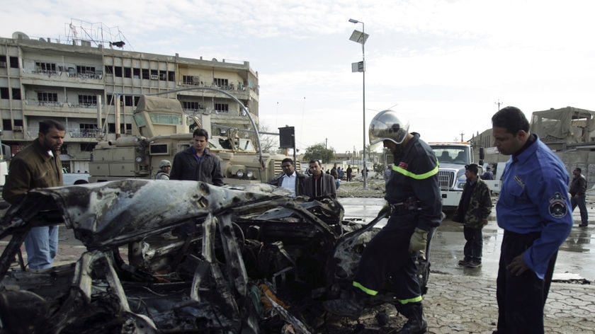 A burnt out car lies at the site of a bomb attack