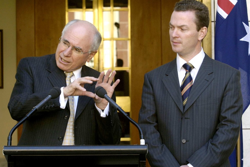 Two men in suits at a lectern