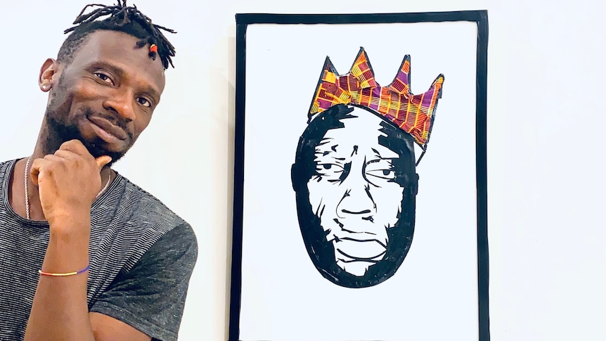 Lucky Lartey with hand to chin standing next to his Biggie design in which Biggie wears a Kente crown