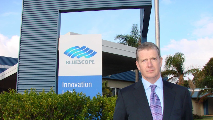 Banner for BlueScope with a frowning chief executive Paul O'Malley at Port Kembla