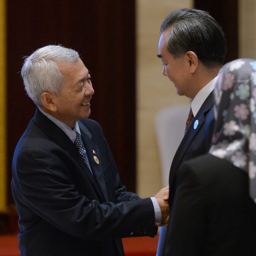 China's Foreign Minister Wang Yi shakes hands with Philippine Foreign Secretary Yasay Perfecto
