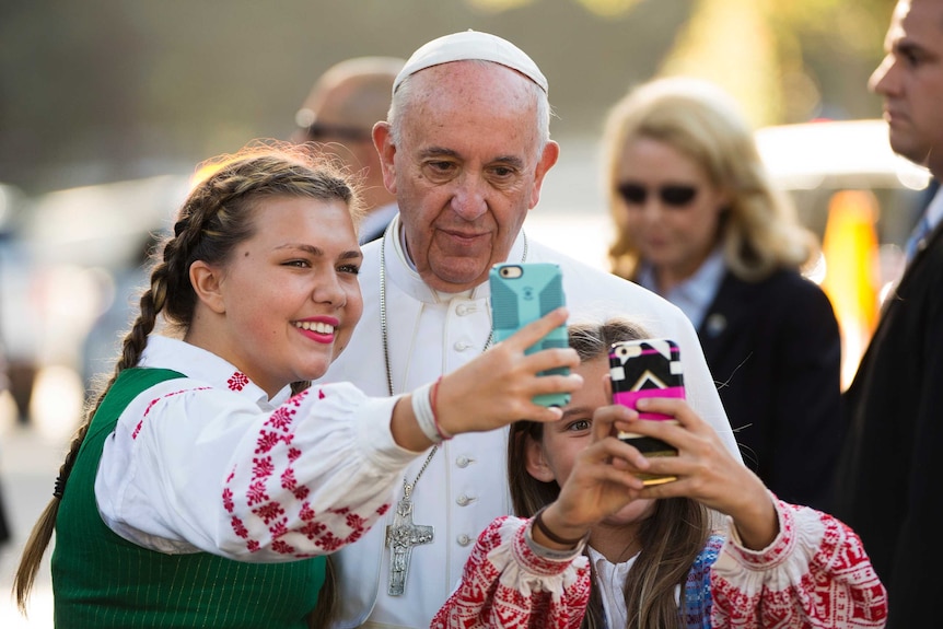 Pope Francis takes a photo with children