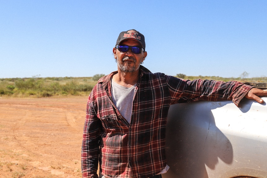 an indigenous man standing in the outback
