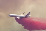 Red fire retardant being dropped from a plane.