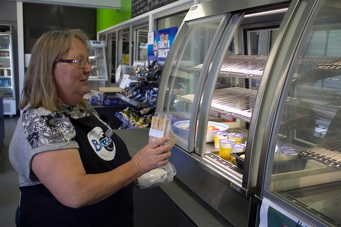 Mansfield State High School tuckshop lady Sharene Rapisardi stocks a fridge for students.