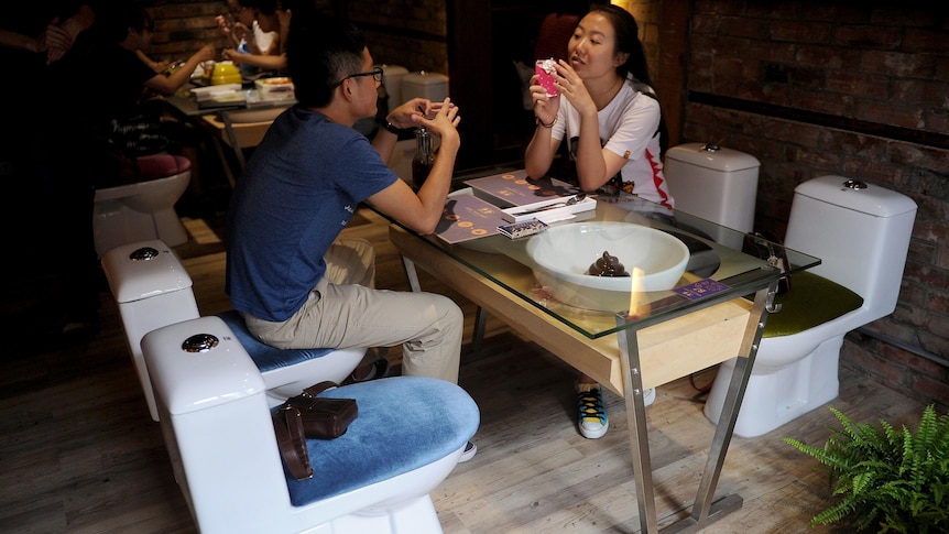 Customers sit on toilet-shaped seats in a toilet themed restaurant in Shanghai.