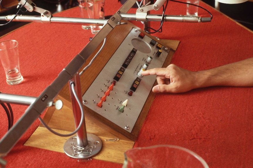 Archival close-up image of ABC radio studio table with microphones and console in the 1980s.