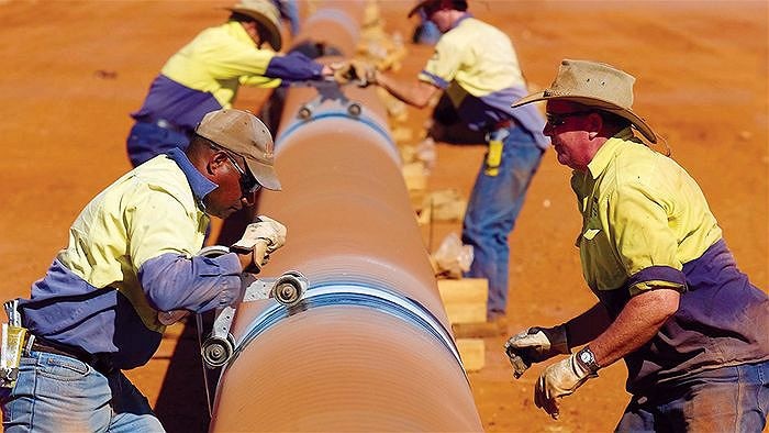 Workers build a gas pipeline in Queensland