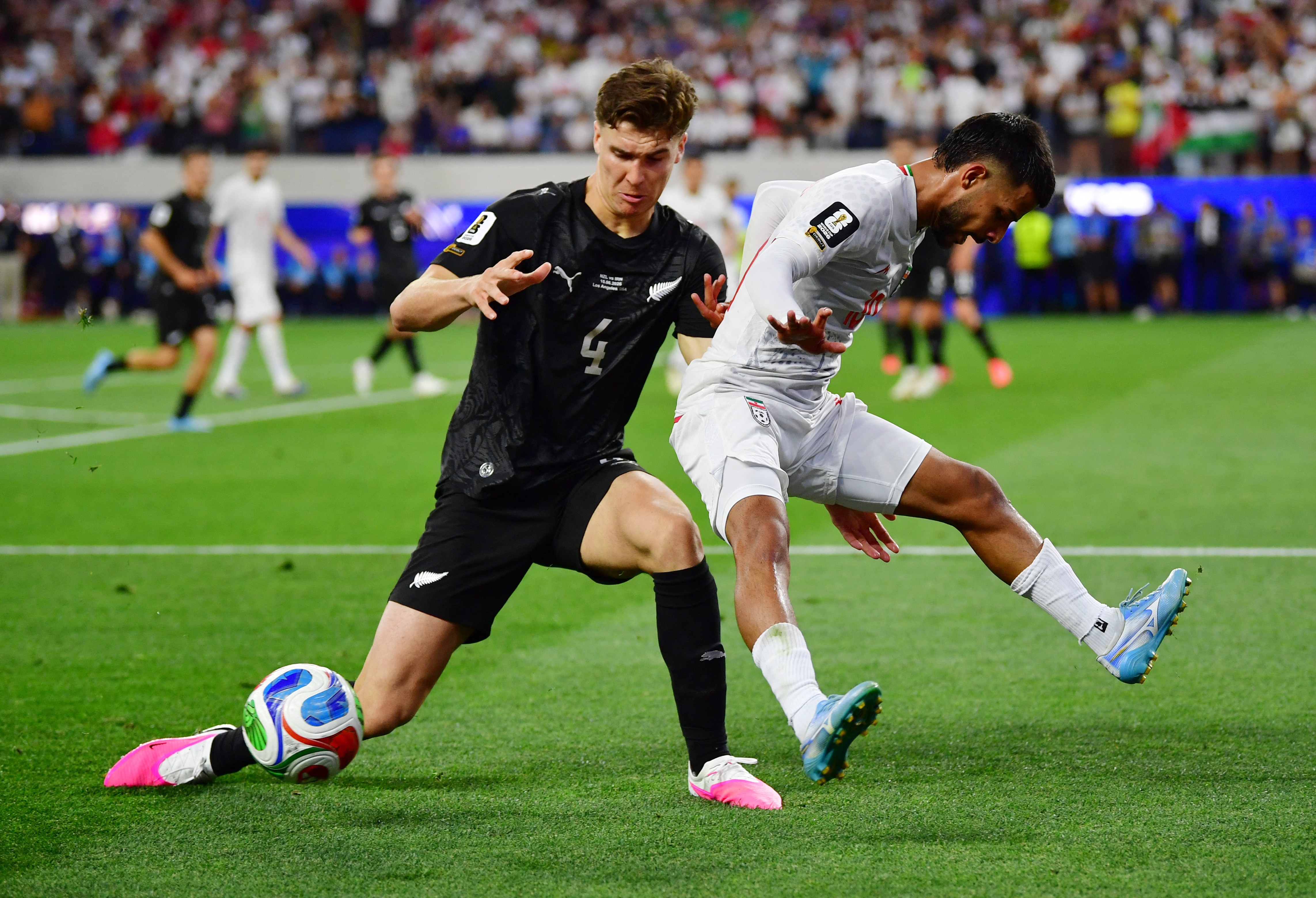 New Zealand's Tyler Bindon and Iran's Mehdi Ghayedi contest for the ball at the 2026 World Cup.