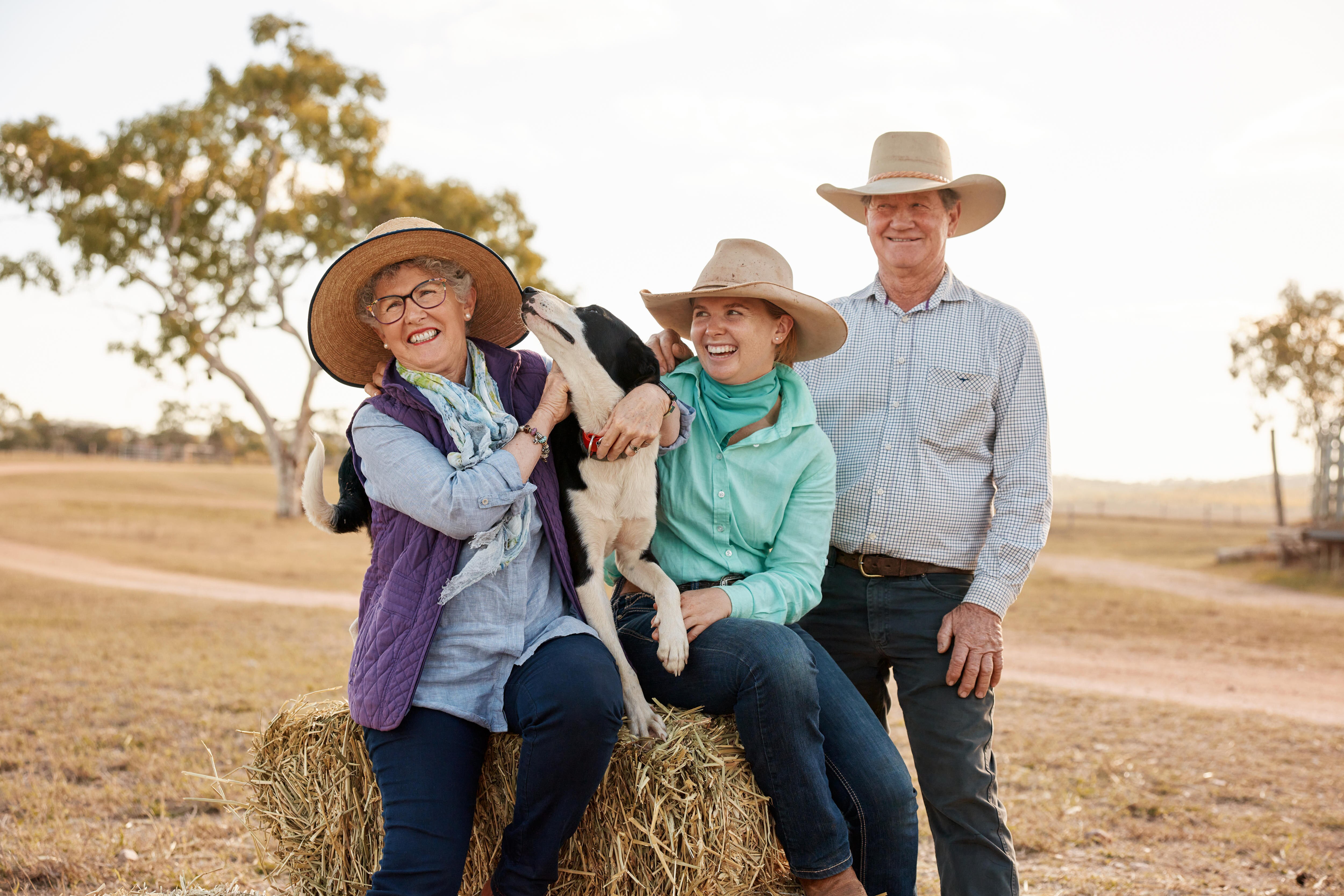 A young woman and a dog with two older people.