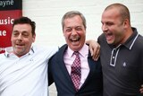 Nigel Farage (C), celebrates with well-wishers during a stop at a pub to greet newly elected councillors.