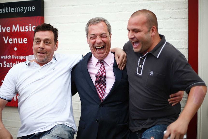 Nigel Farage (C), celebrates with well-wishers during a stop at a pub to greet newly elected councillors.